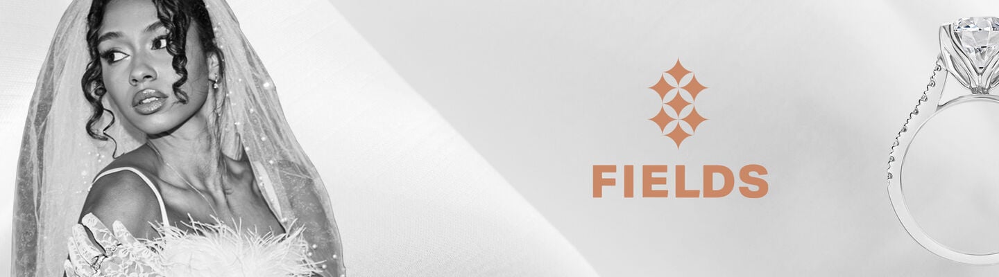 Luxury diamond engagement ring beside a bride in a veil, showcasing Fields engagement rings.