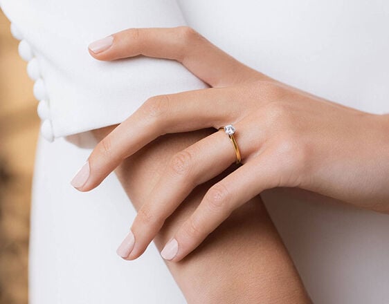 Elegant hand wearing a Tulip Setting diamond engagement ring in yellow gold, exclusive Fields design